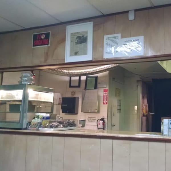 The interior of Just Jerk, showing a service counter with food warmers and a "No Smoking" sign.