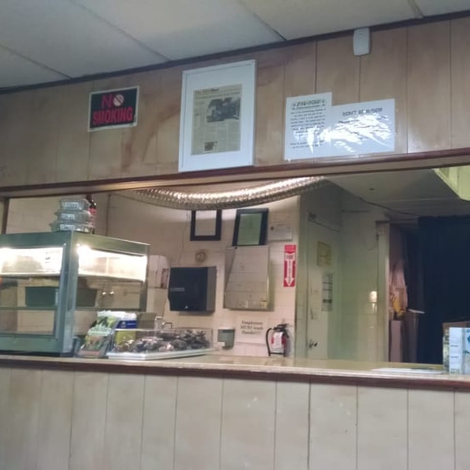 The interior of Just Jerk, showing a service counter with food warmers and a "No Smoking" sign.