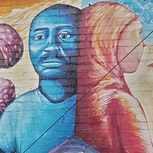 Mural of a blue-skinned man facing forward and a red-skinned woman in profile, divided by a diagonal line.